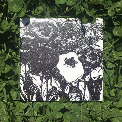 Ceramic tile coaster. Poppies and cat. Image of top black and white floral with cat coaster. Vitrene by Christine and Bruce Green. Pottery and artwork from Micanopy Florida.